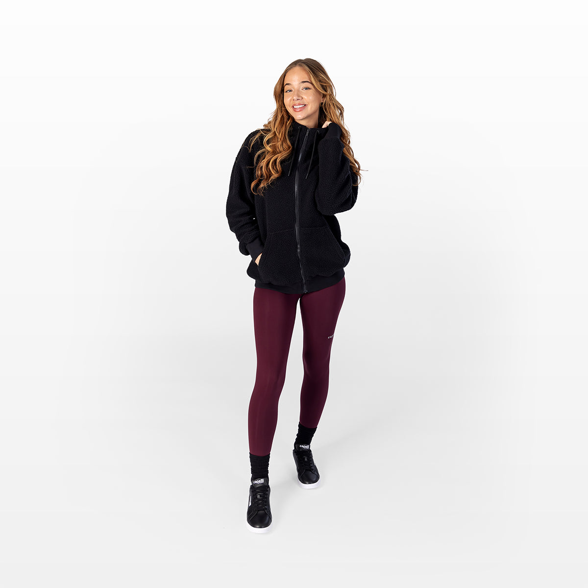 Women's black sherpa zip-up hoodie on model, full front view