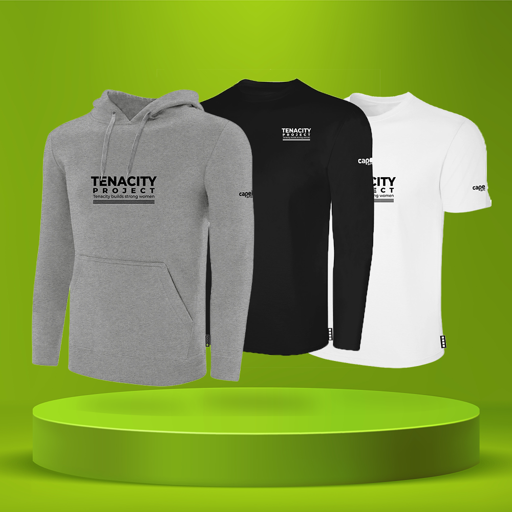 Three apparel items from Tenacity Project are displayed on a green gradient background with a matching green pedestal. The front item is a heather gray pullover hoodie, the middle item is a black long-sleeve shirt, and the back item is a white short-sleeve t-shirt.